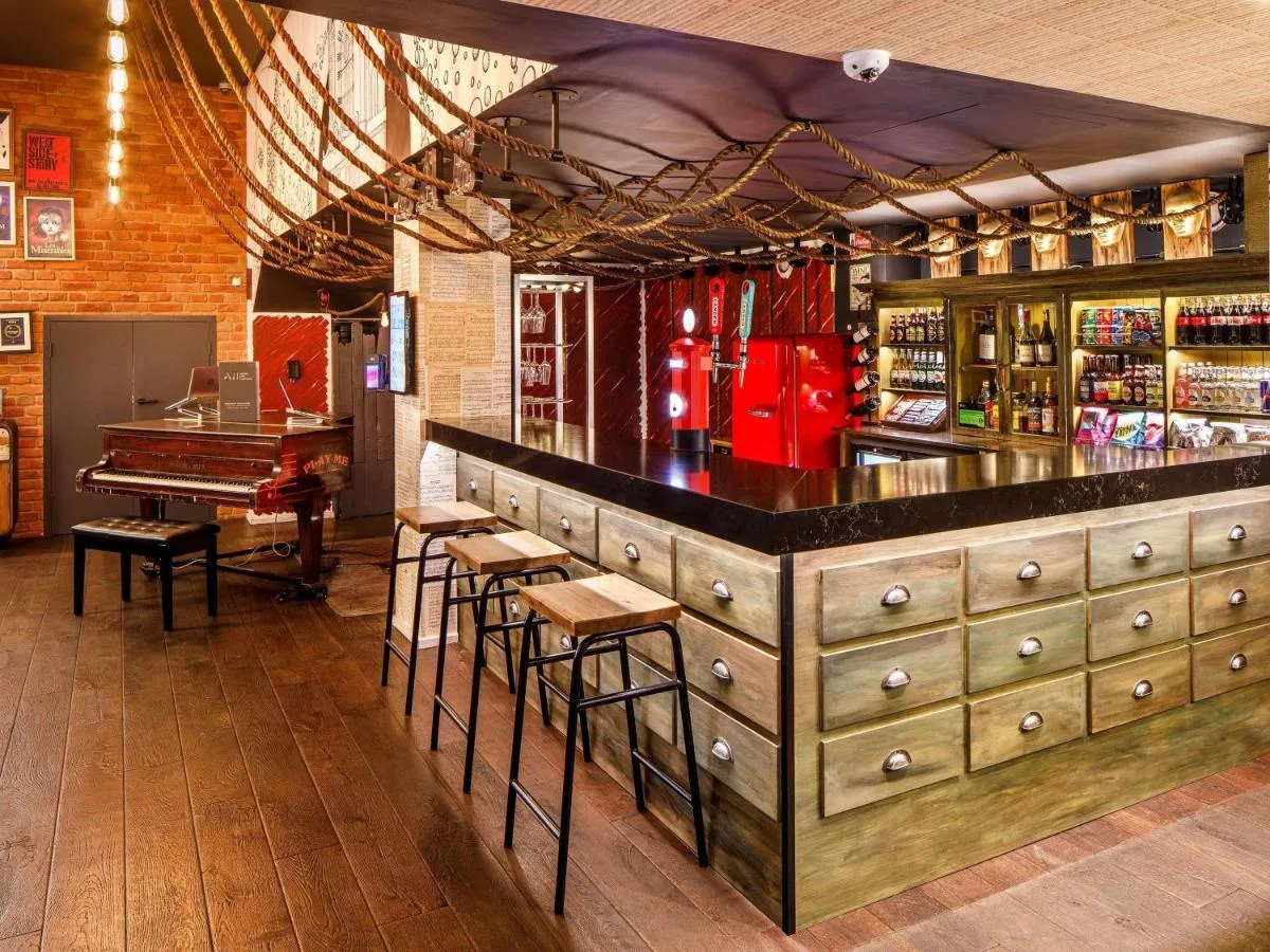 Bar area with stools and a piano at the Southwark hotel